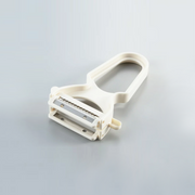 A white Yoshikawa double-blade peeler featuring both straight and julienne stainless steel blades on a grey background.