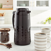 Zojirushi 1L black thermal pot in a kitchen setting with coffee mugs and a jar of beans.

