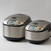 A size comparison of the Zojirushi MICOM Logic Rice Cooker, showing the 5.5-cup model next to the larger 10-cup model.

