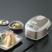 The Zojirushi Micom Rice Cooker 3 Cups NS-LAQ05 as part of a Japanese meal setting with tempura and side dishes.

