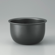 The thick, black, non-stick inner cooking pot of the Zojirushi Micom Rice Cooker shown against a grey background.

