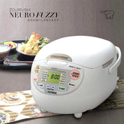 Zojirushi Neuro Fuzzy Rice Cooker NS-ZAQ10 on a dining table with a Japanese meal set in the background.

