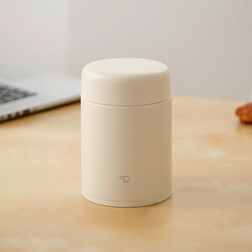 A studio photo of the Zojirushi SW-KA40 vacuum insulated food jar in beige, shown from the front highlighting its seamless one-piece lid.