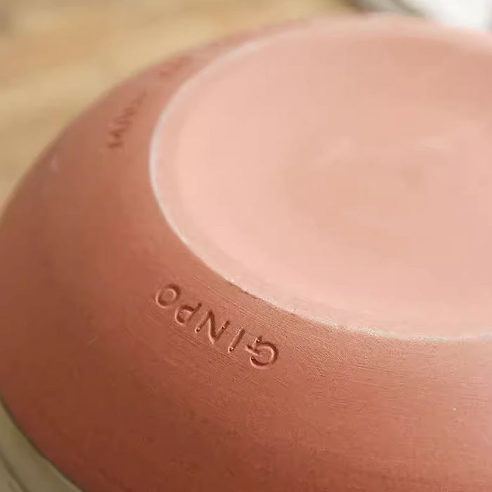 The bottom of the Ginpo Hana Mishima Mini Donabe Japanese Clay Pot, showing the brand name 'GINPO' etched into the clay. The base is a natural terracotta colour.