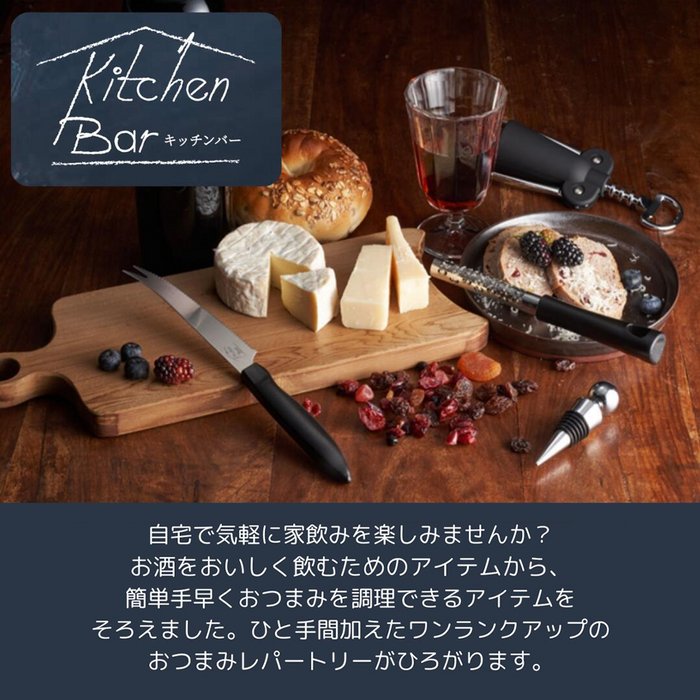 A serving board with assorted cheeses, a glass of wine, and a Shimomura Kitchen Bar stainless steel peeler displayed in a kitchen bar setting.