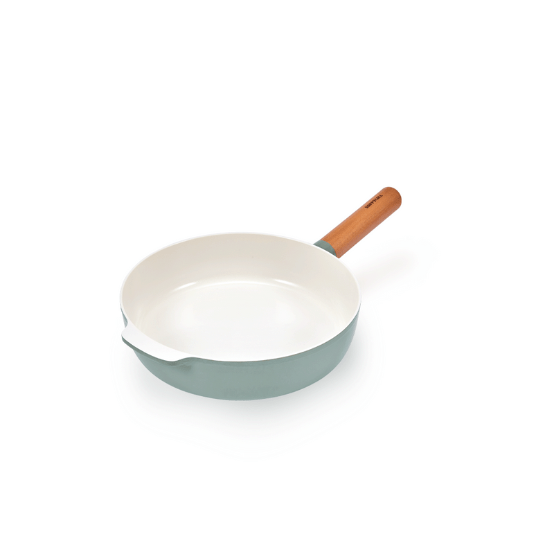 The 24cm Happycall Zium ceramic nonstick induction frypan, showing its sage green exterior, white cooking surface, light wood handle, and pouring spout.

