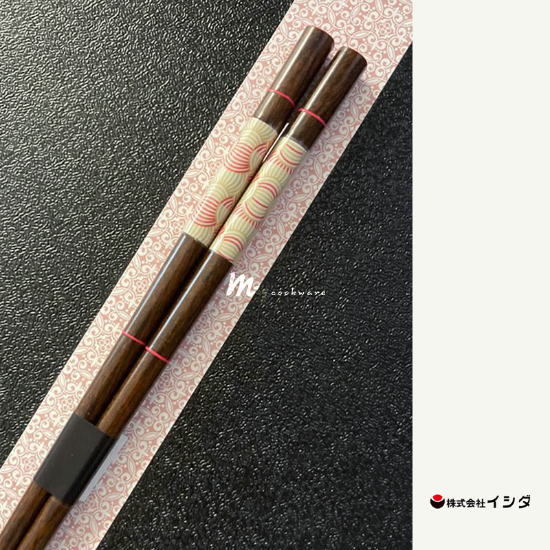 A pair of Ishida Fiore Wakasa-Nuri chopsticks, featuring a dark wood finish and a pink and cream patterned handle, shown in their retail packaging.
