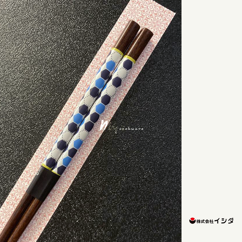 A pair of Ishida Fiore Wakasa-Nuri chopsticks, featuring a dark wood finish and a blue, white, and black hexagonal pattern on the handle, shown in their retail packaging.
