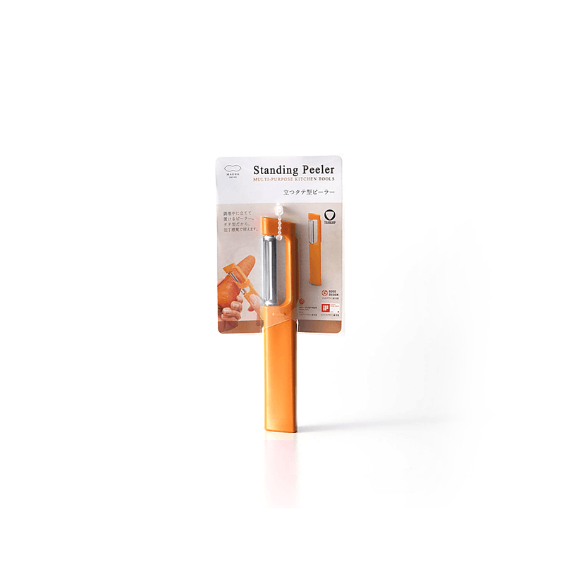 The Marna Standing Peeler, an orange self-standing kitchen tool, shown in its official retail packaging.
