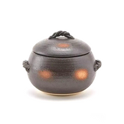 A product image of the Misuzu Donabe Rice Pot, showing its unique rustic design with a dark textured glaze and twisted clay handles.