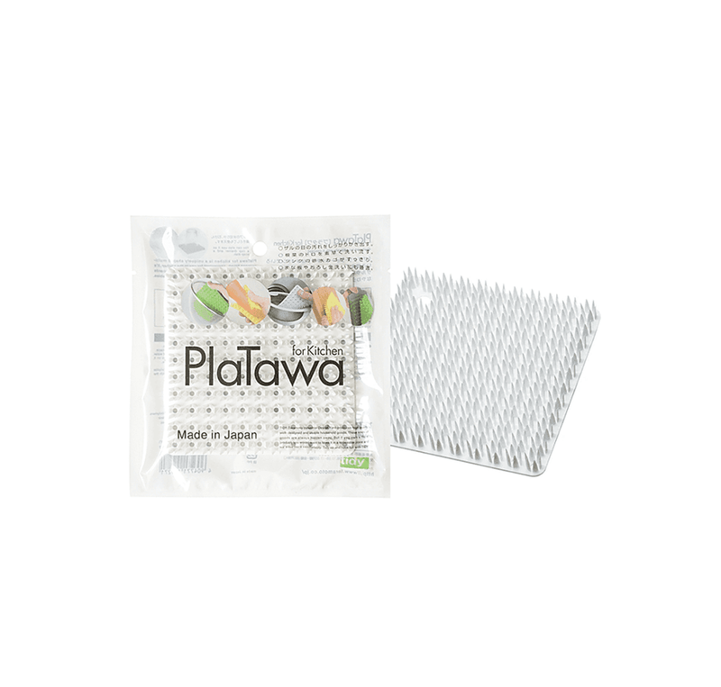 The Tidy PlaTawa Multipurpose Brush, a flexible white cleaning tool with soft bristles, shown next to its official Japanese retail packaging.
