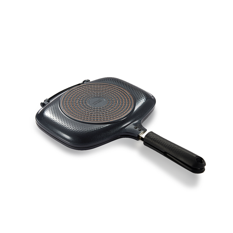 The closed Happycall IH Synchro Double Pan, angled to show the circular induction base on its textured grey exterior.
