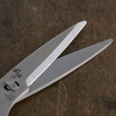 A detailed close-up of the sharp, precisely ground stainless steel blades of the Kai Seki Magoroku kitchen scissors.
