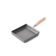 The River Light Kiwame 18x18cm square tamagoyaki omelette pan, made from nitrided carbon steel with a wooden handle.
