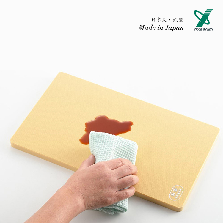 Yoshikawa Anti-bacterial PE Cutting Board being cleaned with a cloth, showing its liquid-resistant surface.