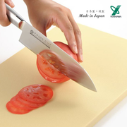 Cutting a tomato on the Yoshikawa Anti-bacterial PE Cutting Board with a sharp knife.