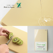 Close-up of Yoshikawa Anti-bacterial PE Cutting Board's textured surface and cutting a kiwi.